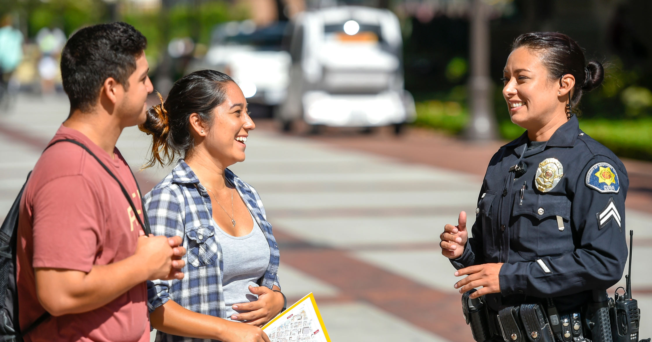 USC Safety Officer smiling and speaking with two students on campus