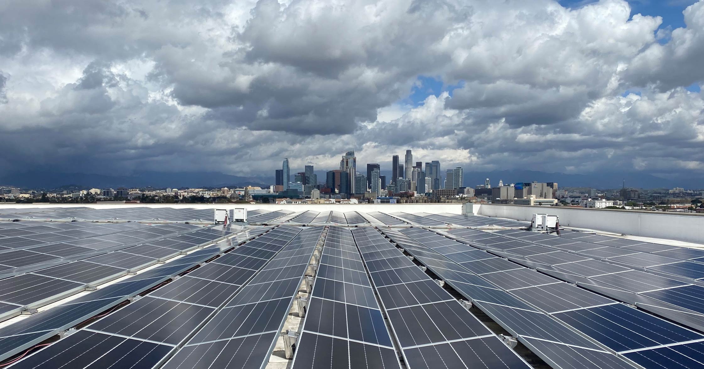 USC Sustainability solar panels against sky with downtown Los Angeles in background