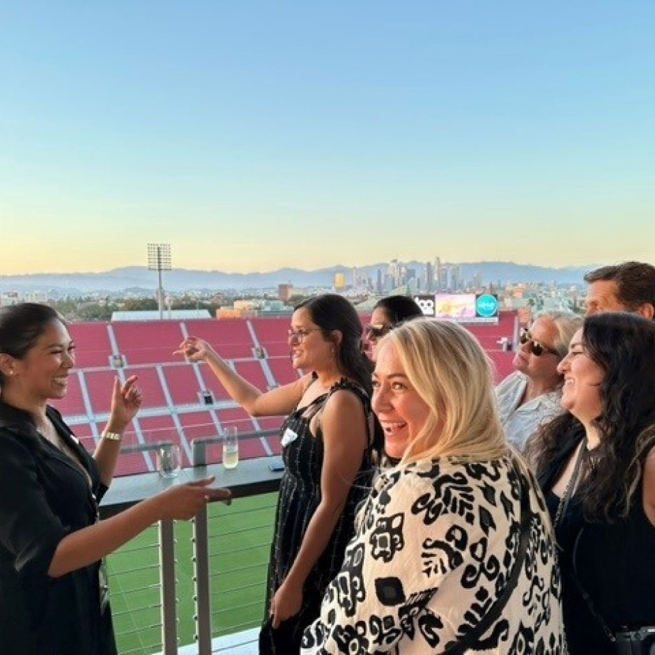 L.A. Coliseum staff getting tour of Coliseum at sunset with downtown Los Angeles in background