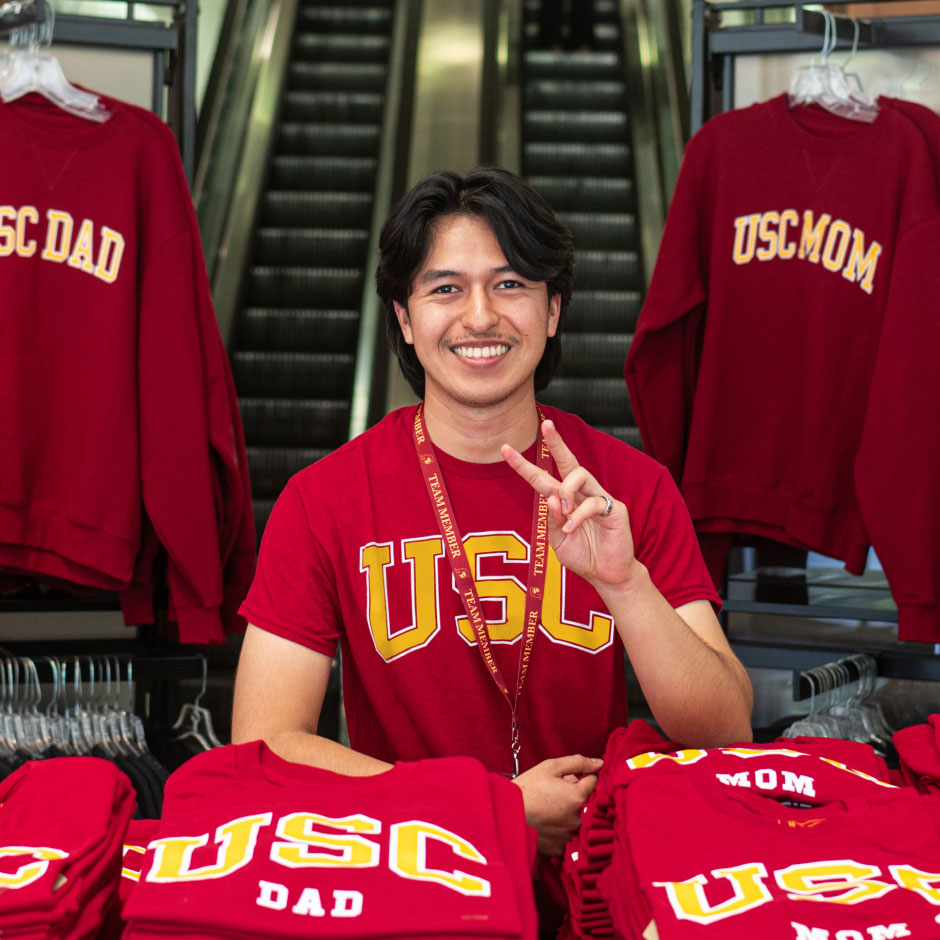 USC student worker posing with fight on fingers at USC Bookstore
