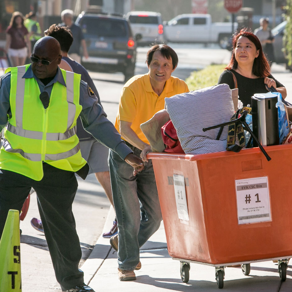USC Housing guard helping new parents and students with large move-in bin on move-in day