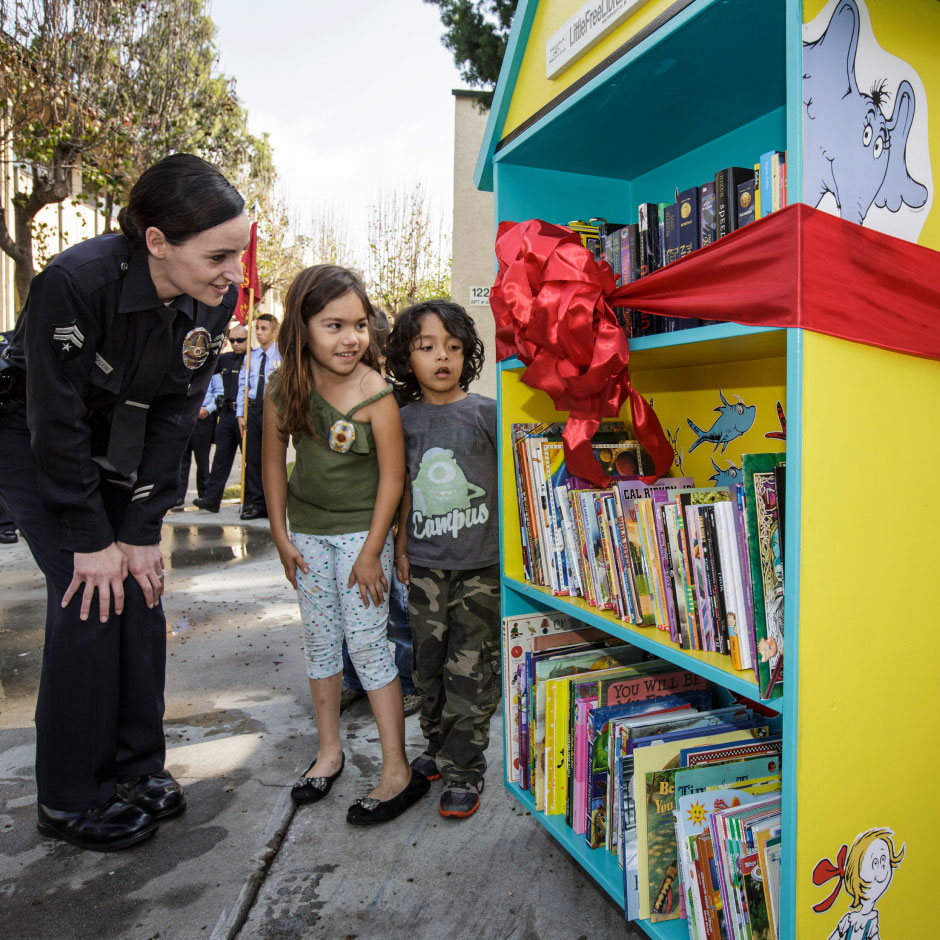 USC police officer unveiling little free library with neighborhood children